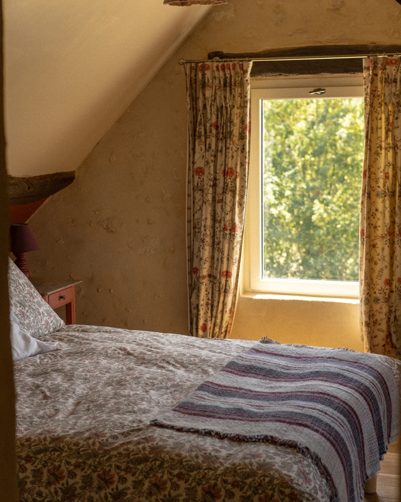 La chambre de la suite, sous le rampant, sa fenêtre ouverte sur les arbres