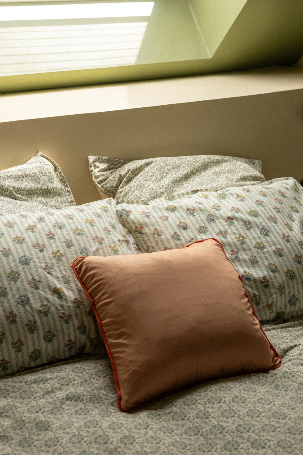 Le lit et son coussin terracotta, sous les combles