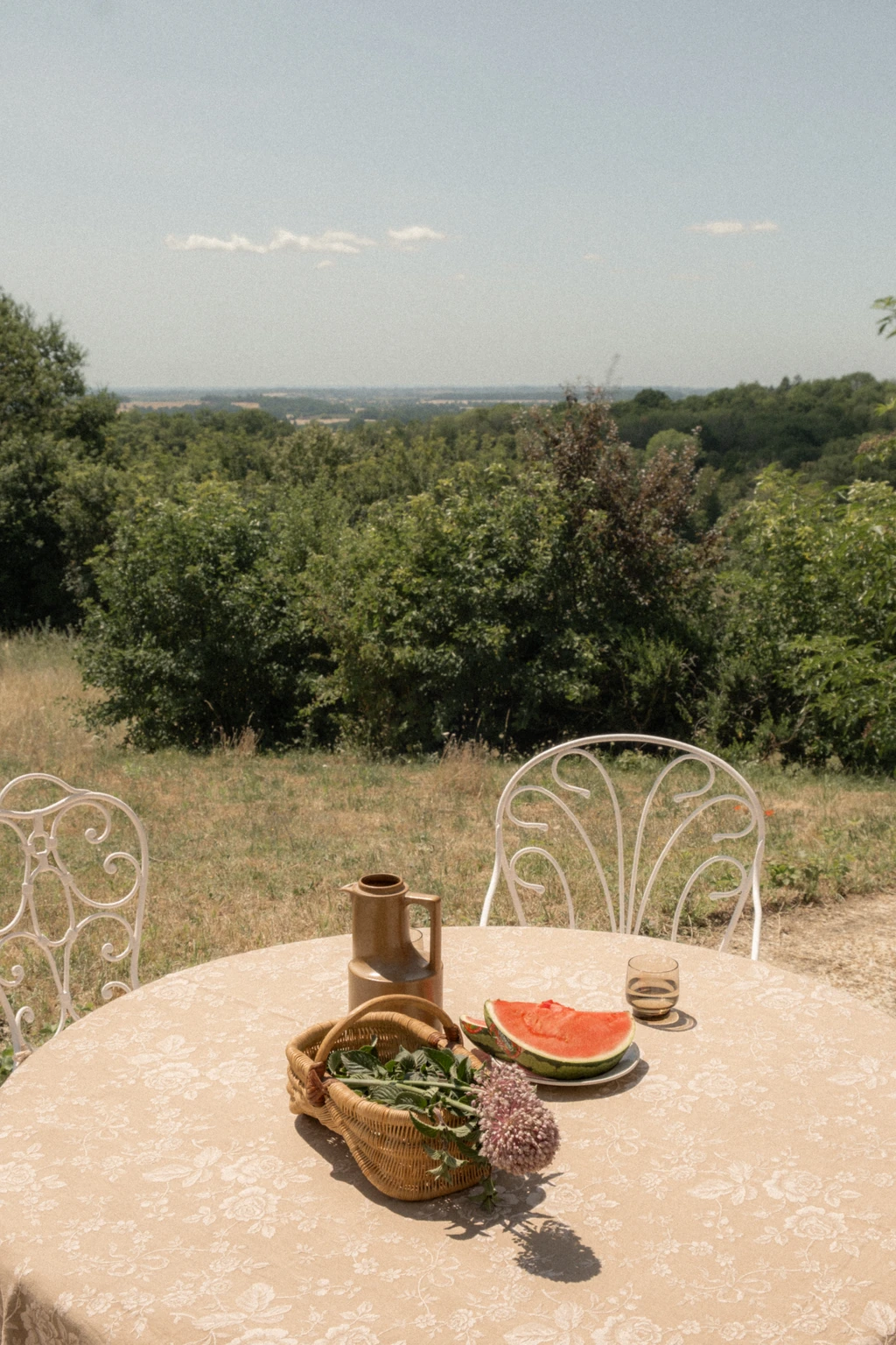 La table dressée sur la terrasse, la campagne du Perche en contrebas